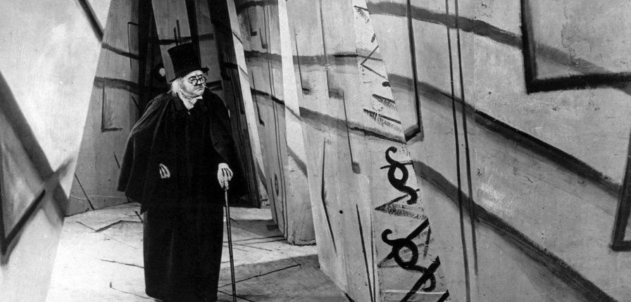 Frame of Dr. Caligari standing in a long hallway